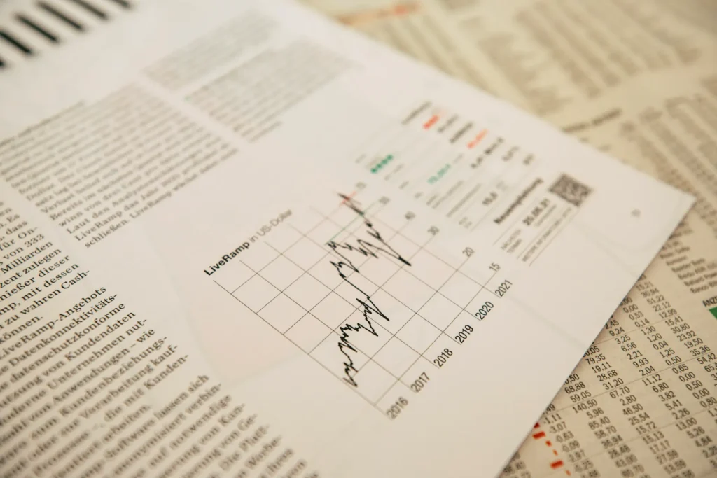 Gráfico de linha sobreposto a uma tabela e texto em um documento financeiro, com indicadores e eixos visíveis em um relatório técnico.